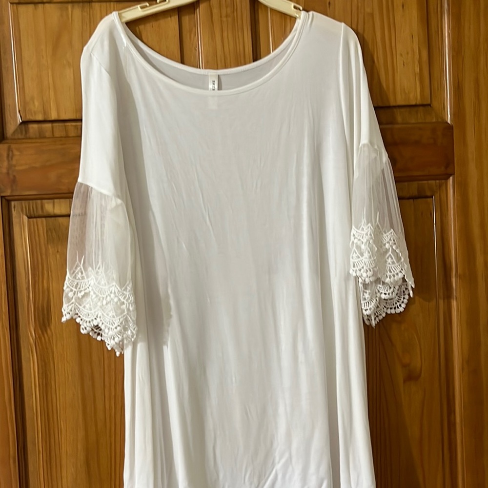 Blouse 3/4 sleeve w/ lace detail. Rayon and spandex. Soft, light ivory color.